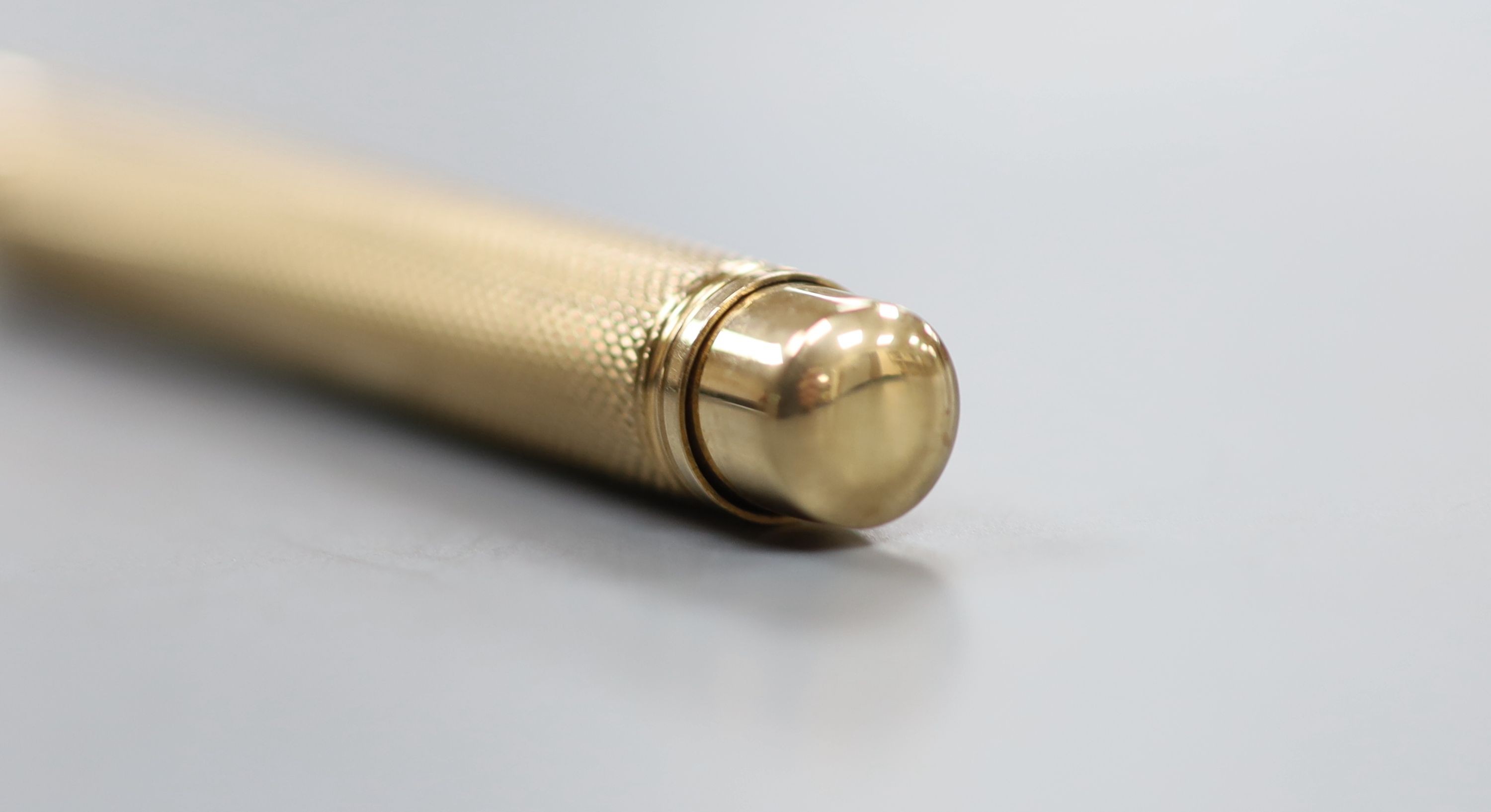 A 1950's engine turned 9ct gold pencil, maker, EB, London, 1956, 78mm, gross 19.2 grams.